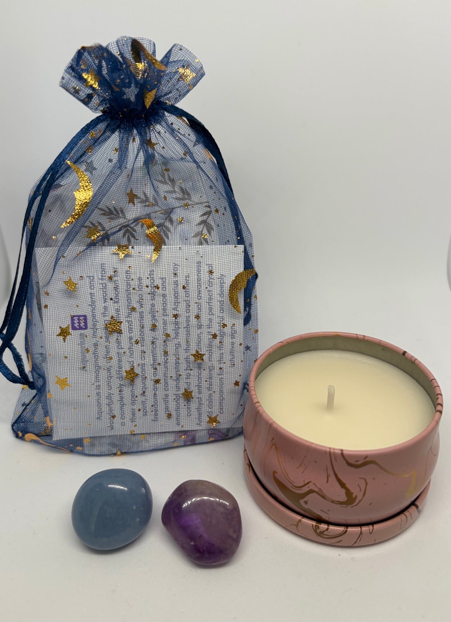 Ceramic candle with decorative packaging featuring stars and text on a white background