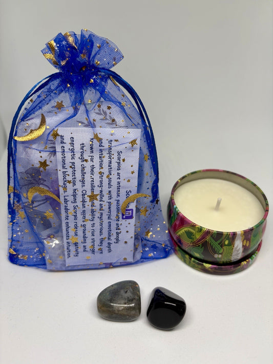 Decorative candle in a tin with a blue gift bag featuring celestial designs on a white background