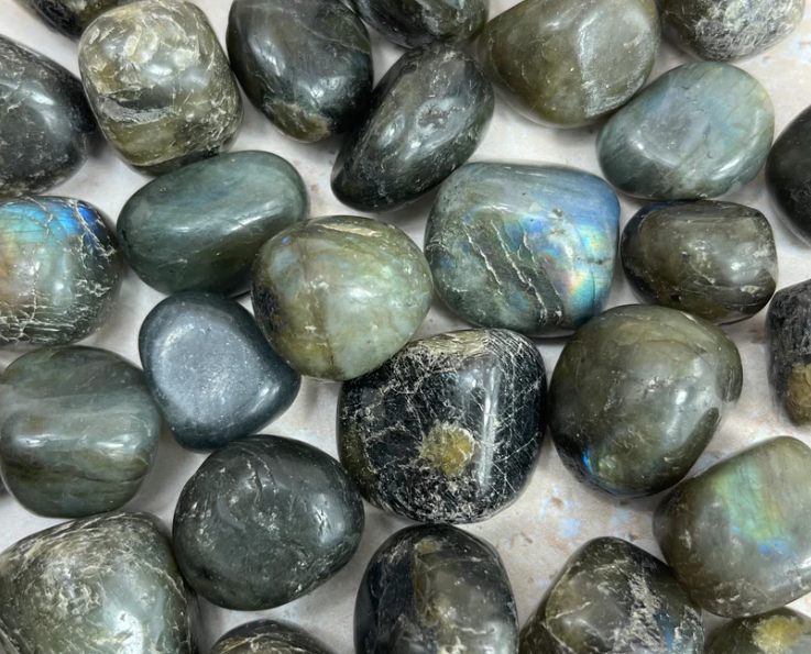 Collection of polished labradorite stones with a metallic sheen.